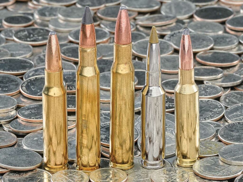 A lineup of deer hunting cartridges on a pile of quarters.
