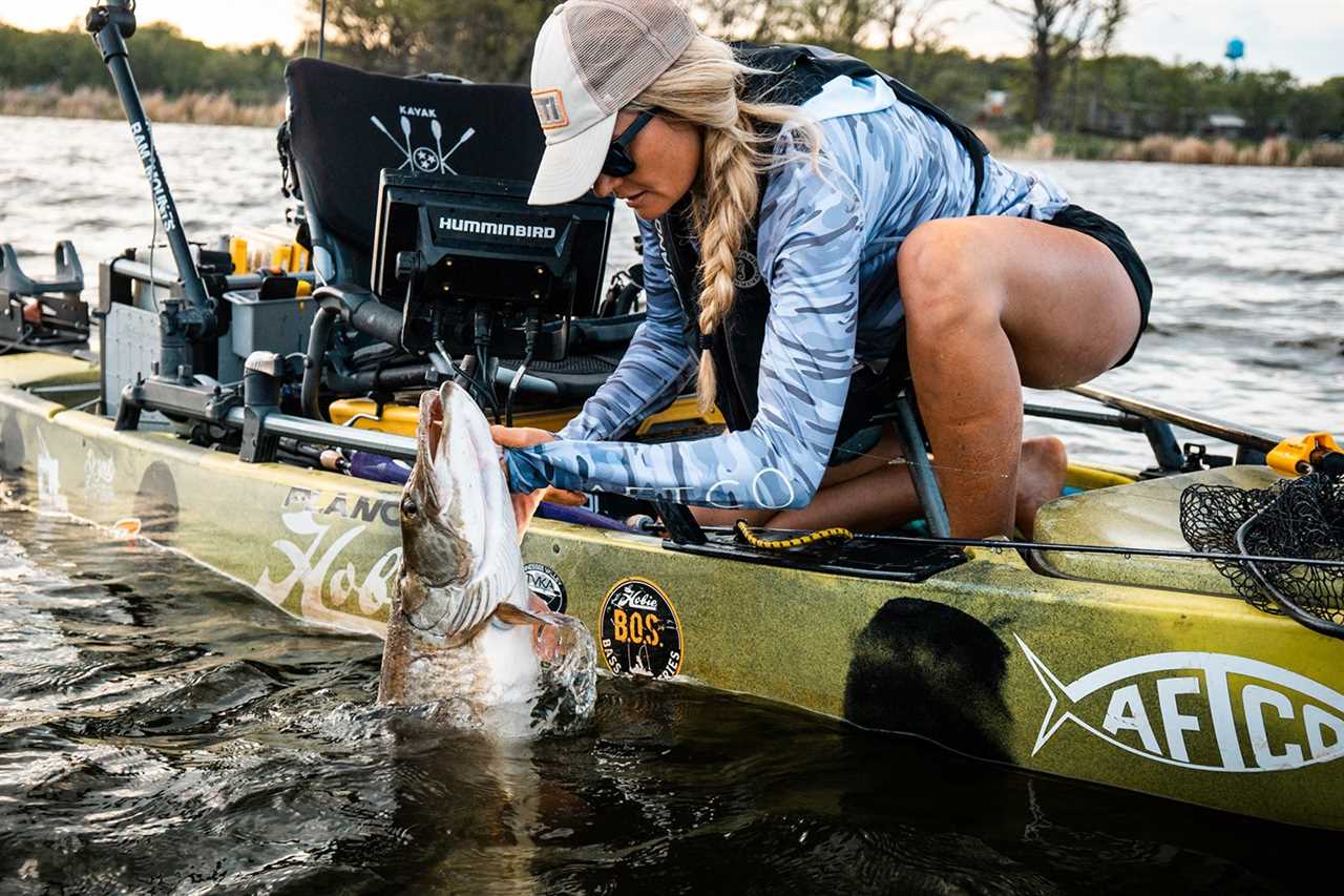 Fischer holds muskie in water