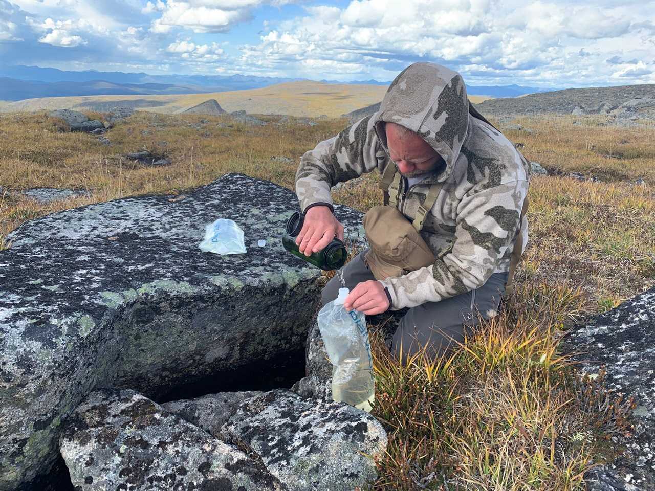 Shultz collects water from underneath a rock