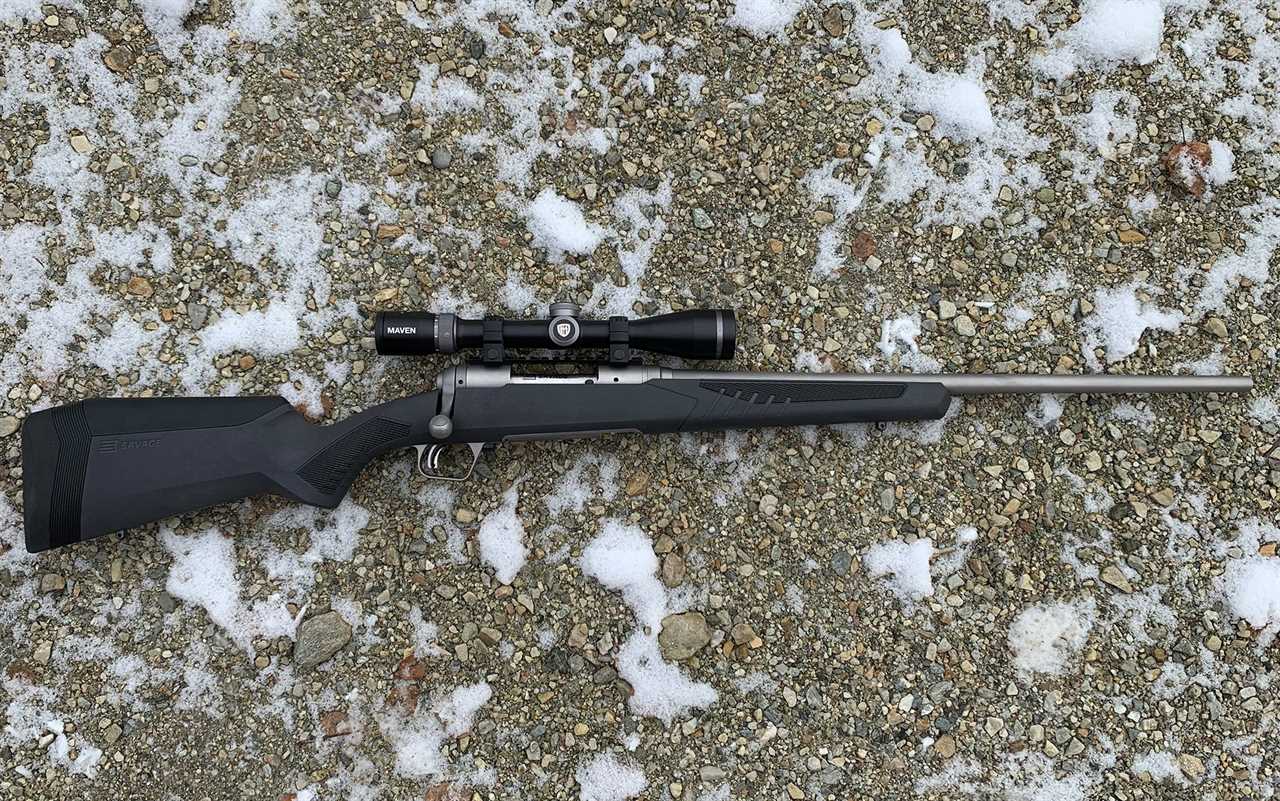 The Savage 110 Storm laying on snowy rocks.