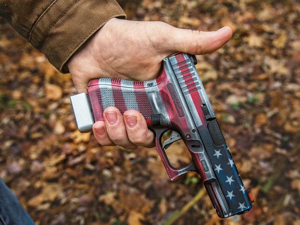 man holding a handgun painted with the american flag