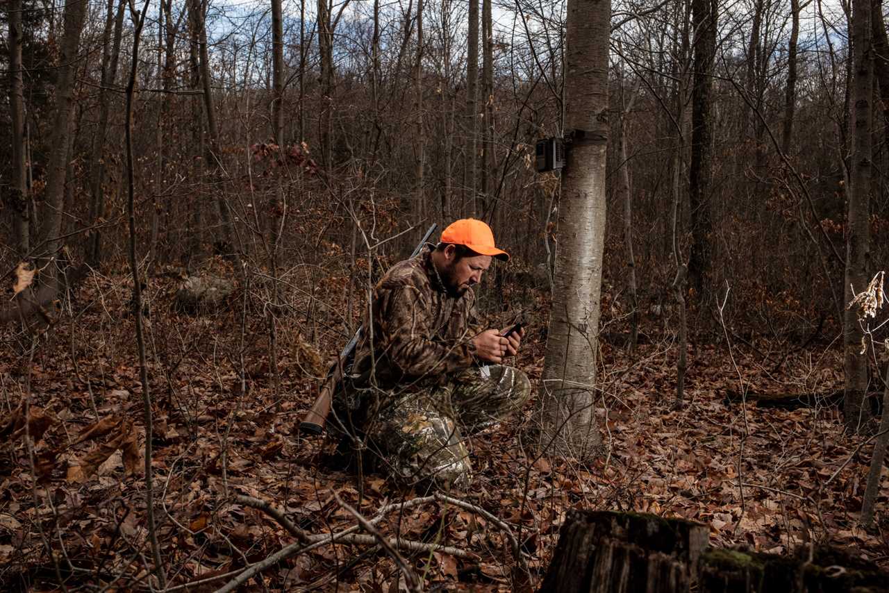 A bear hunter checks his trail camera.