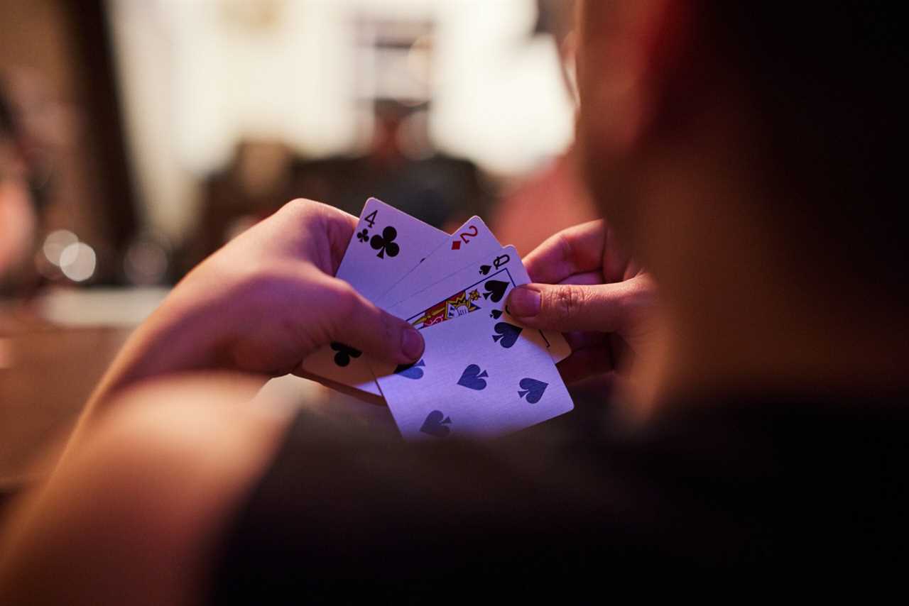 A hunter at deer camp looks at a hand of cards.