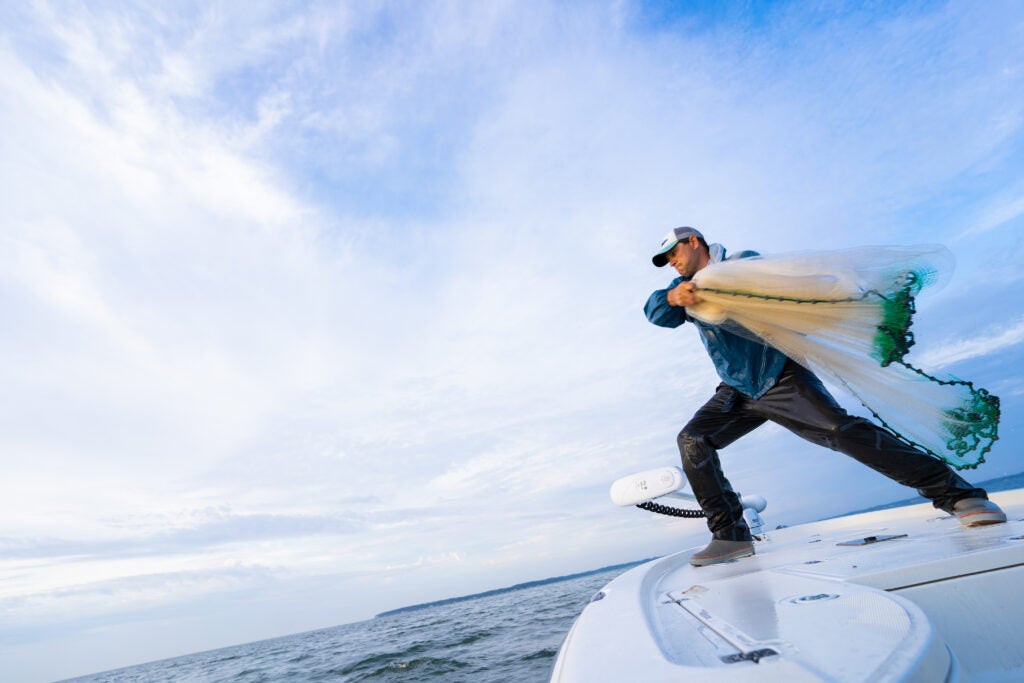 fisherman throwing a cast net 