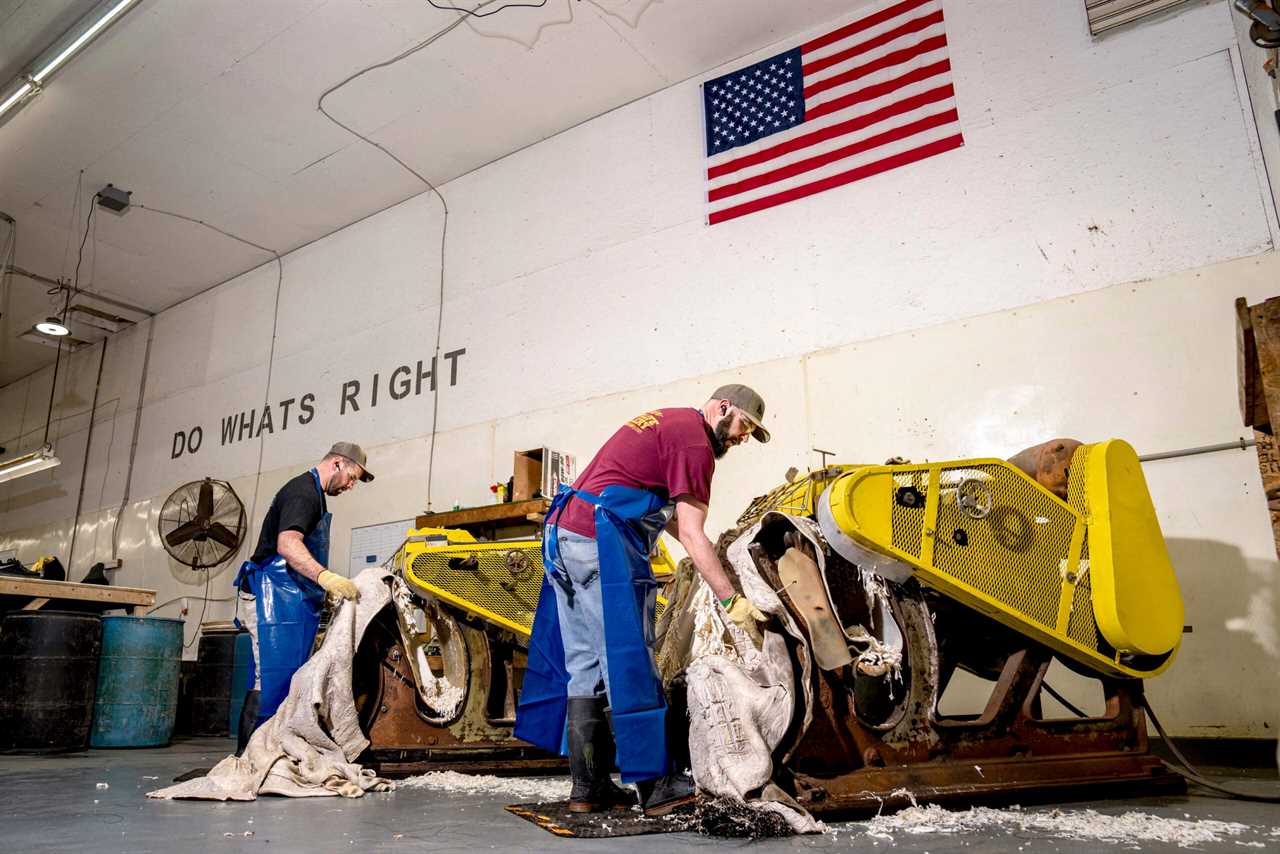 Two brothers work on running hides through a turning machine.