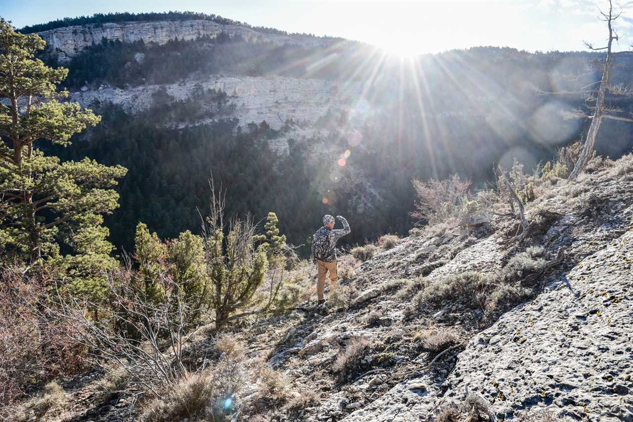 An ibex hunter stands on a steep mountainside in Spain.