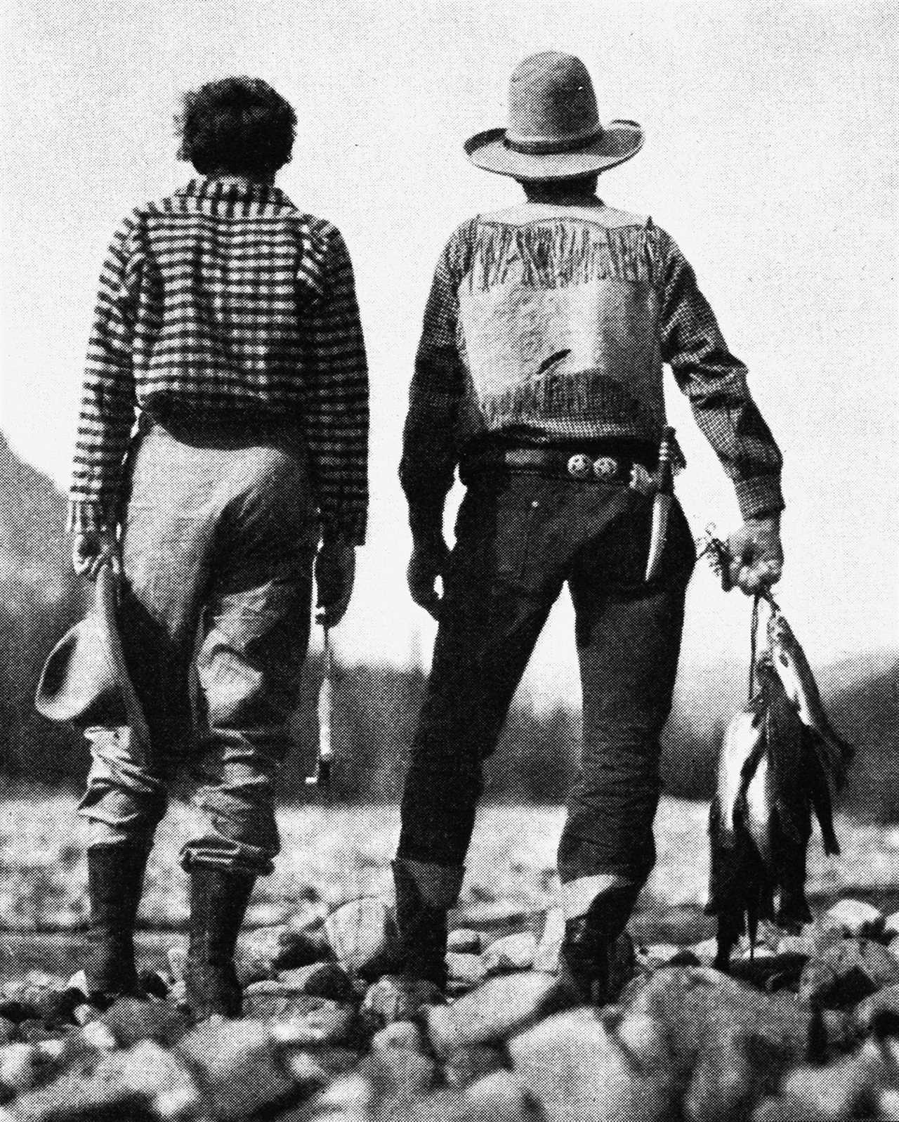 amelia earhart and companion stand near stream with day's catch