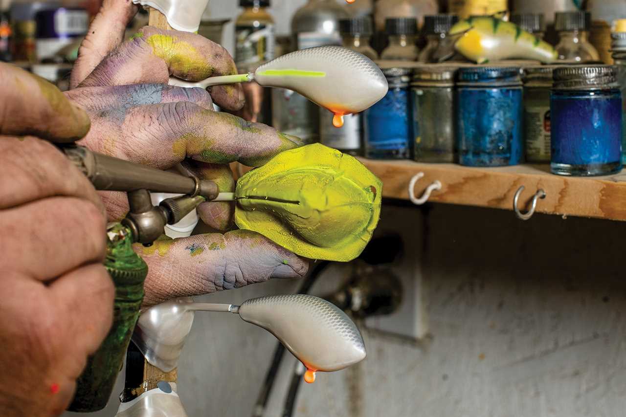 close-up of balsa-wood crankbait being painted with an airbrush