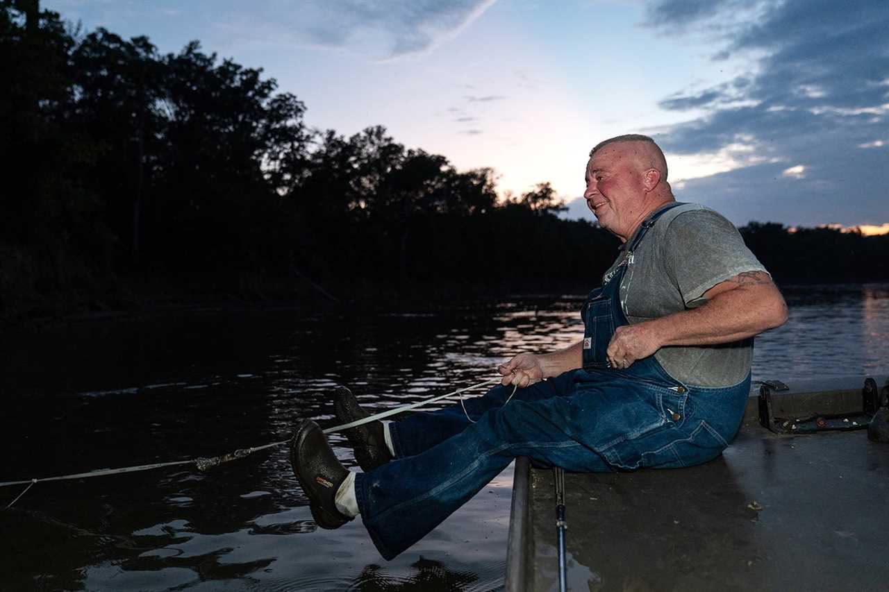 trotliner sits at edge of boat holding line
