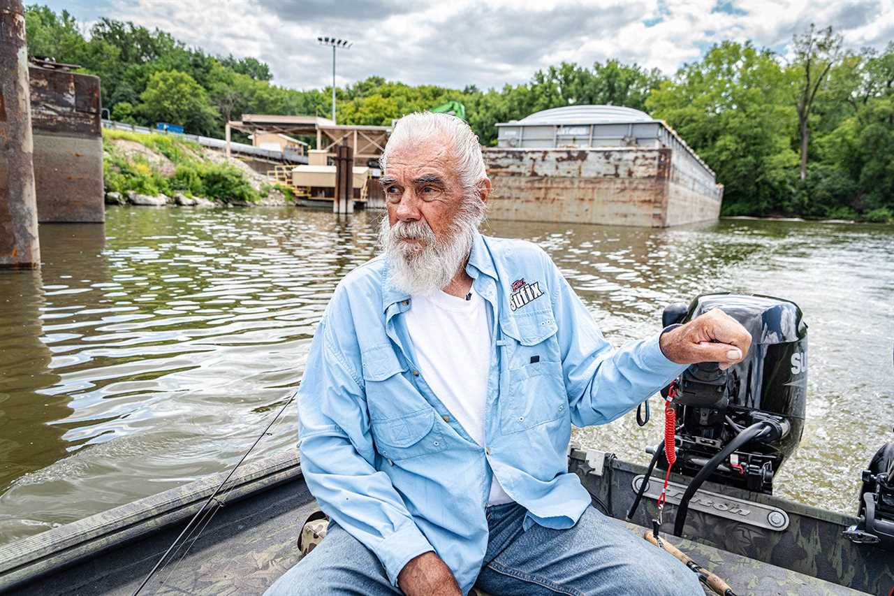 the griz sits in the stern of his boat to steer