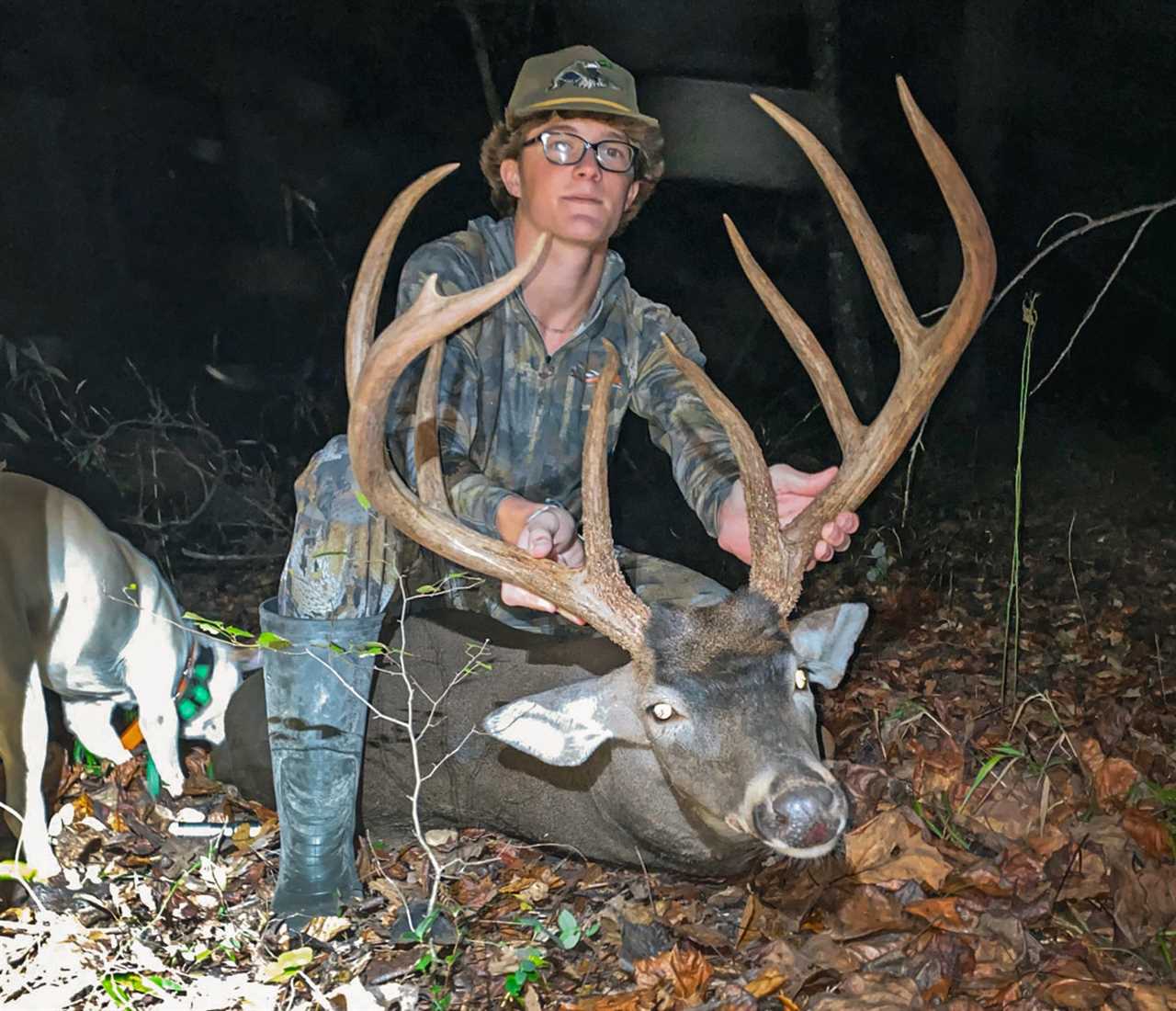 A young hunter holds the antlers of a big buck.