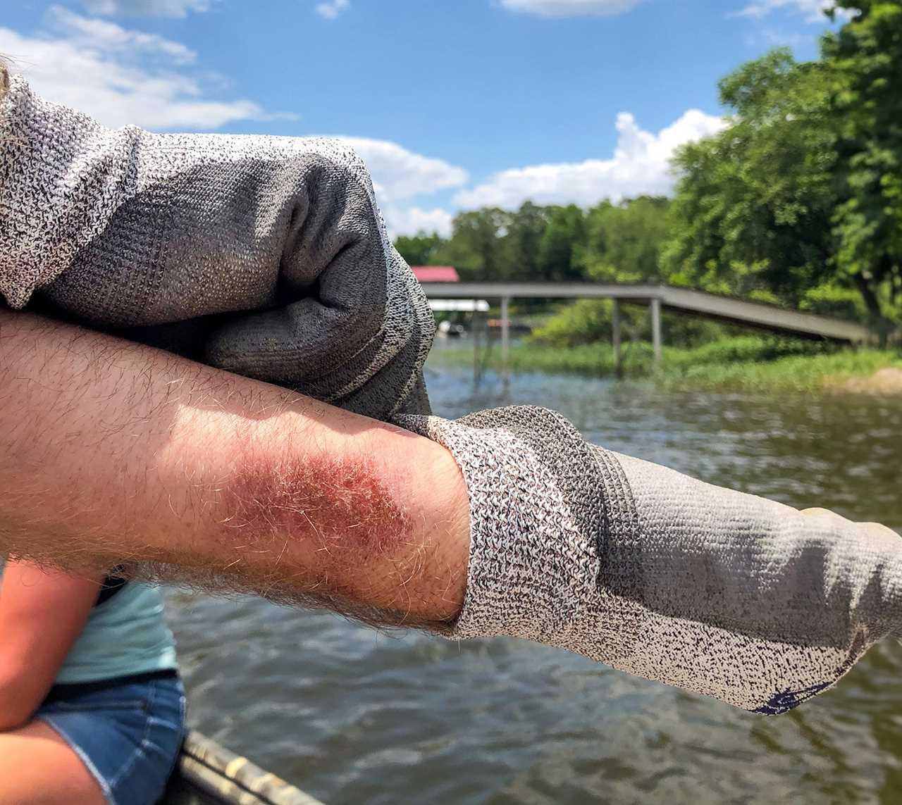 A man pulls on gloves for noodling.