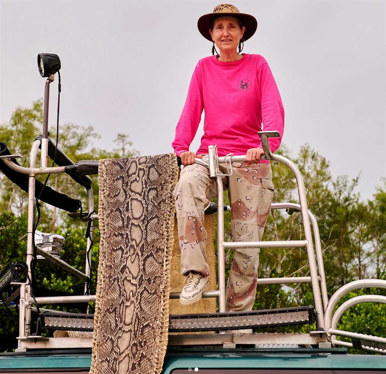 A Florida python hunter with a Burmese python skin.